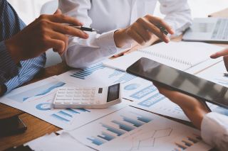 Foto: Personen besprechen Akten